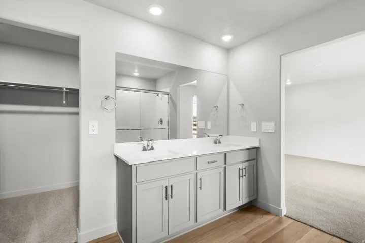 Dual vanity with undermount sinks, white countertop, and light gray cabinetry