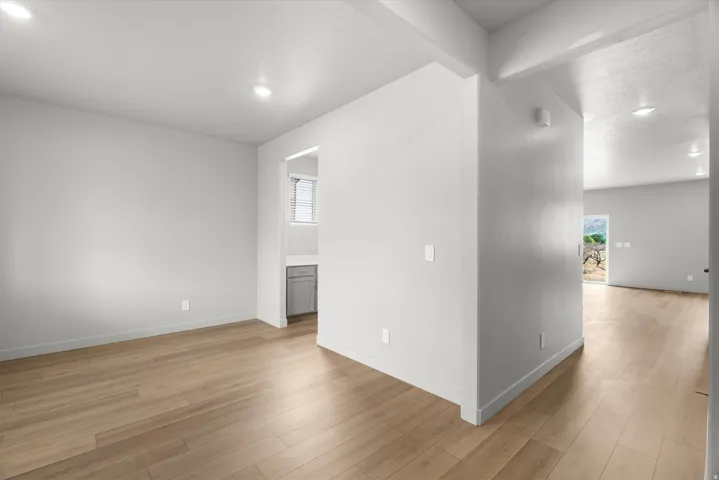 Spacious interior featuring wood-finish flooring, recessed lighting, and crisp white walls