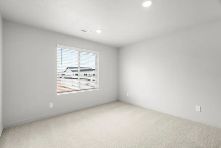 Room featuring neutral carpeting, a large window with horizontal blinds, recessed ceiling lighting, light gray walls, and white trim