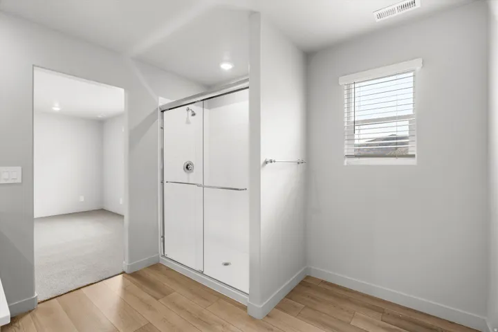 Enclosed shower with glass sliding doors and an integrated shower head