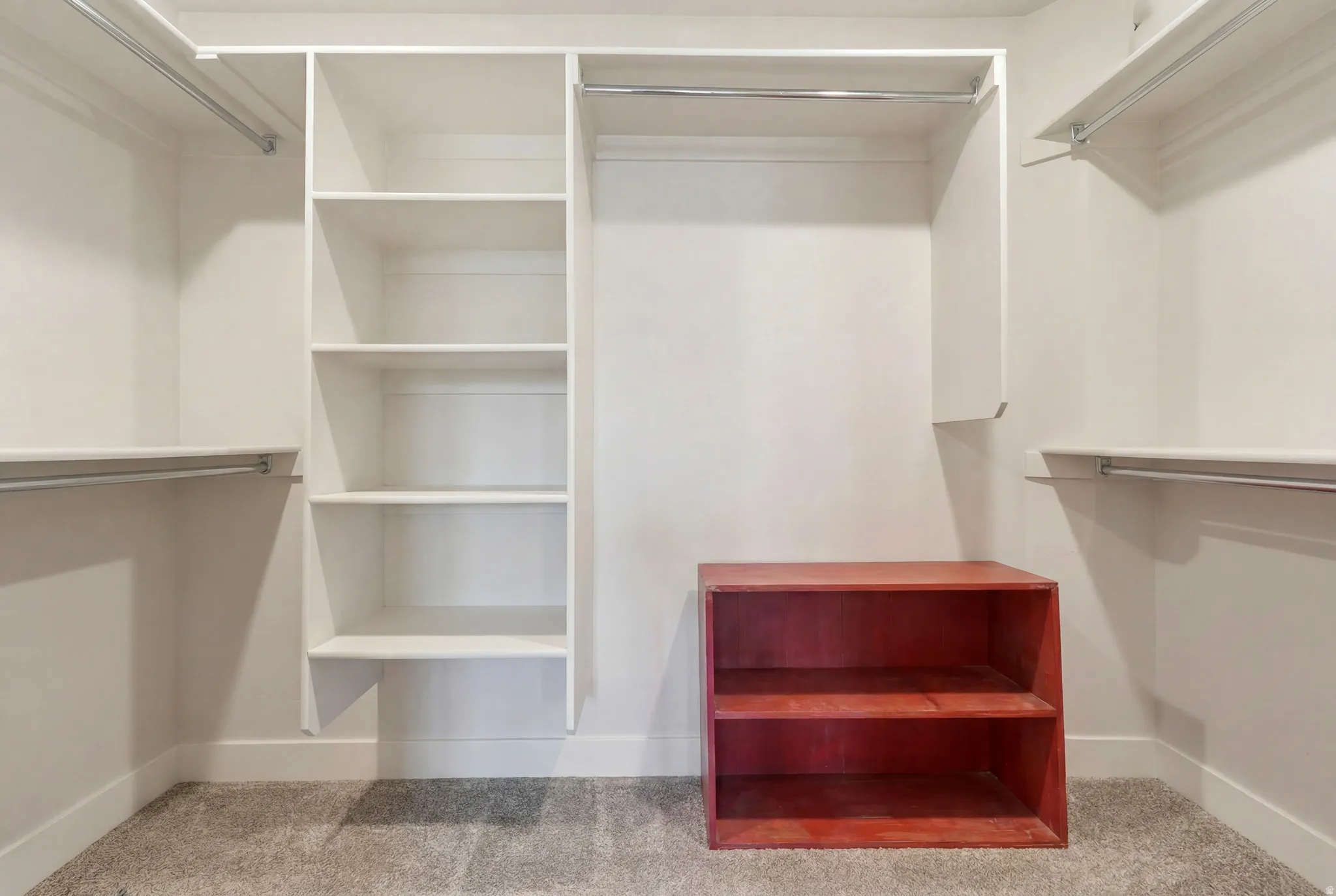 Built-in closet organization system featuring white shelving and hanging rods