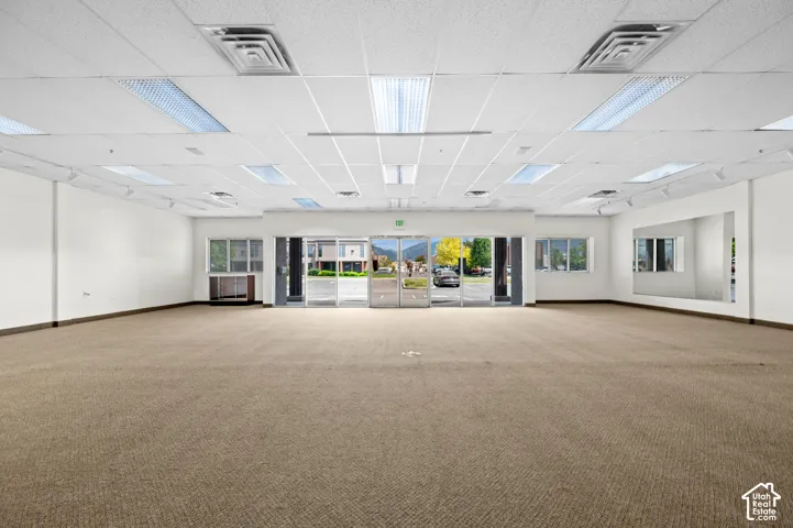 Open commercial space featuring neutral carpet flooring and white painted walls