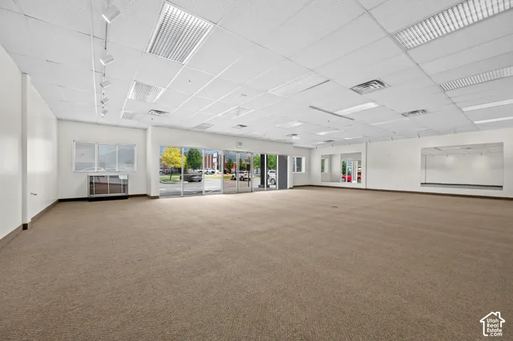 Spacious commercial interior featuring neutral carpeting and white painted walls