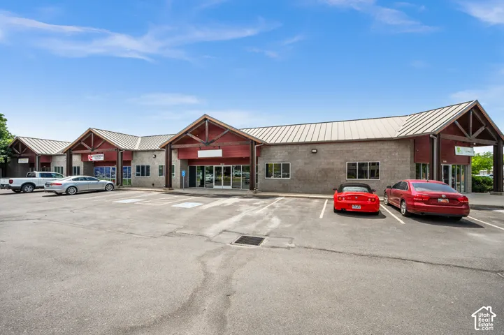 Commercial building featuring multiple storefronts, a metal roof, and exposed wood architectural accents