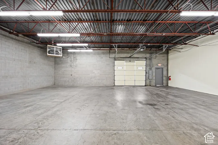 Spacious industrial interior featuring concrete flooring and exposed ceiling trusses