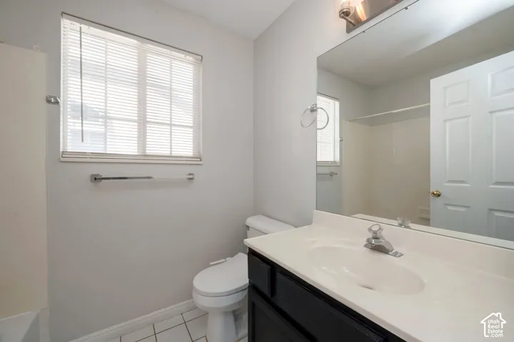 Bathroom featuring a white vanity with integrated sink, chrome faucet, and expansive wall mirror