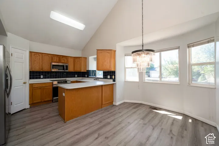 Kitchen and dining area featuring wood-finish flooring and vaulted ceilings