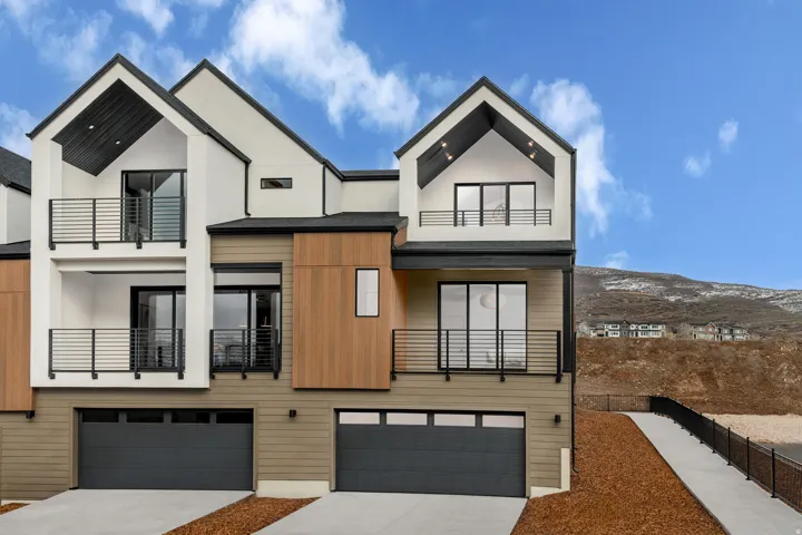 Contemporary multi-level residence featuring a neutral color palette with wood-finish siding accents and white stucco