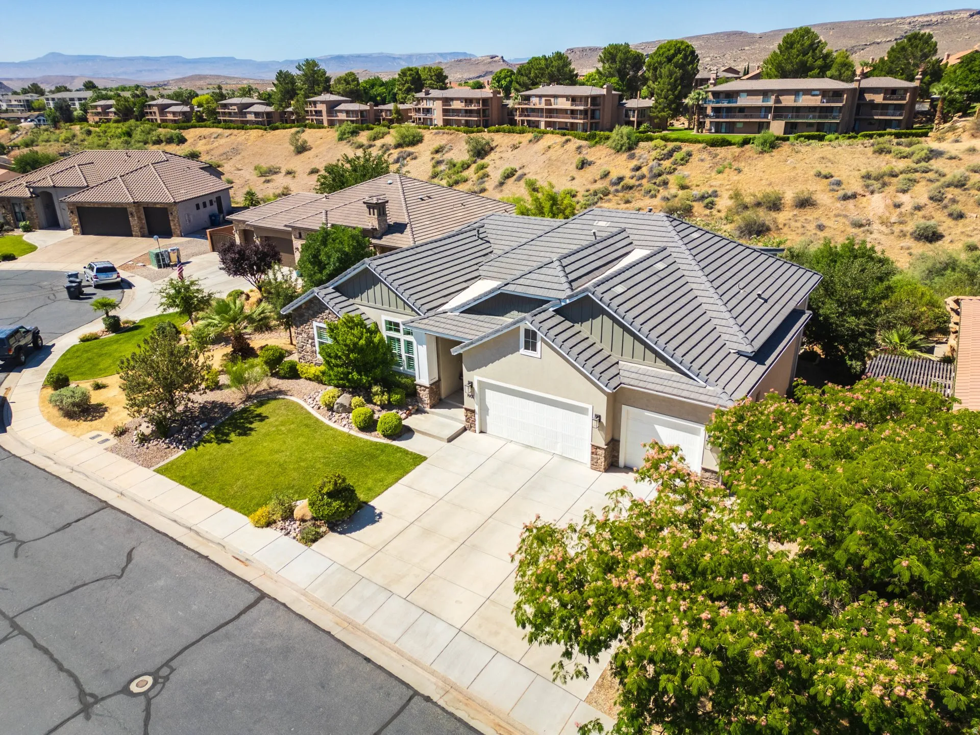 Contemporary single-story residence featuring a two-car garage, concrete driveway, and stone accents