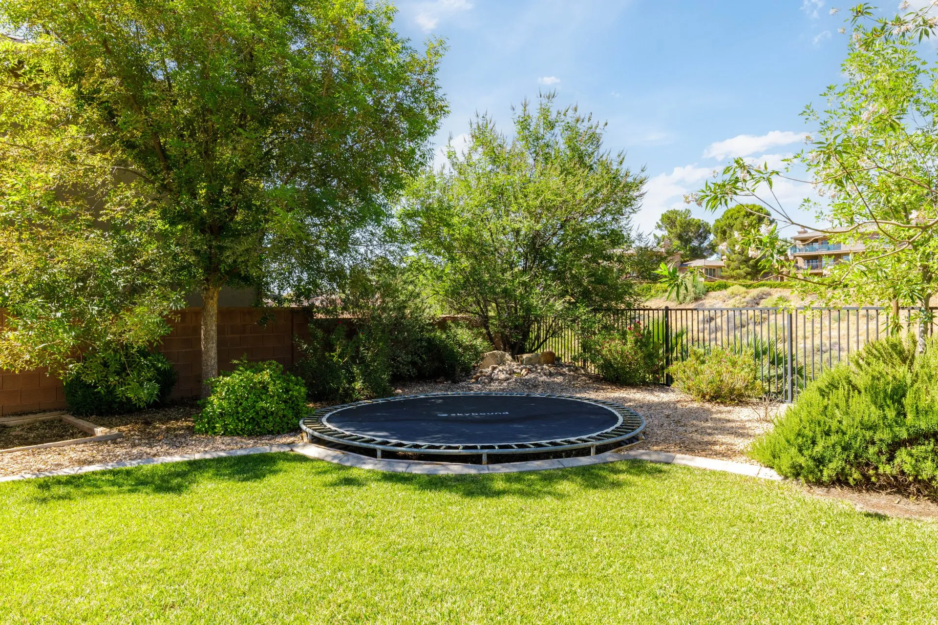 Expansive backyard featuring a lawn, privacy fencing, mature trees, and landscaping
