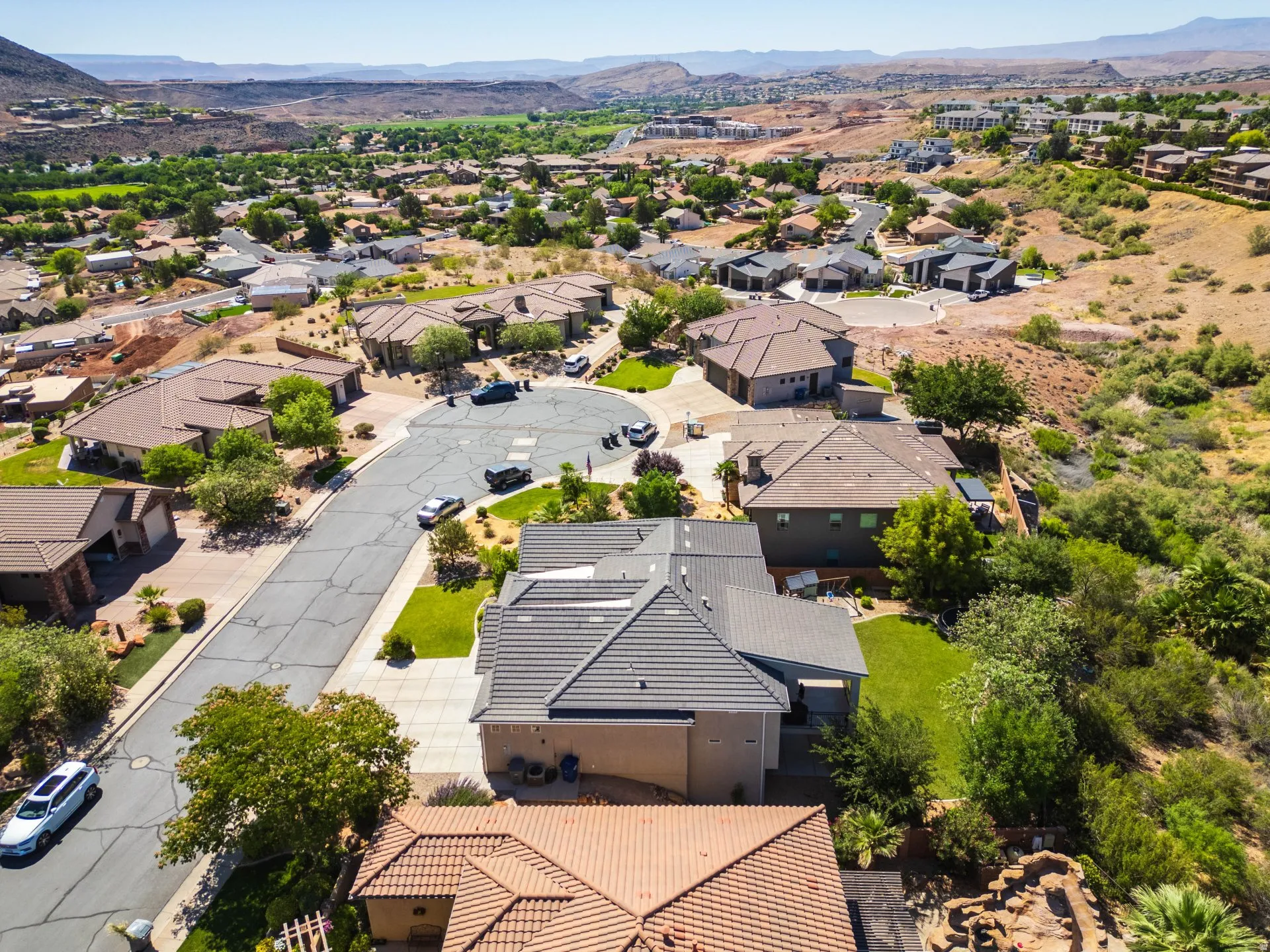 Aerial perspective of a residential neighborhood featuring varied roof styles and landscaping