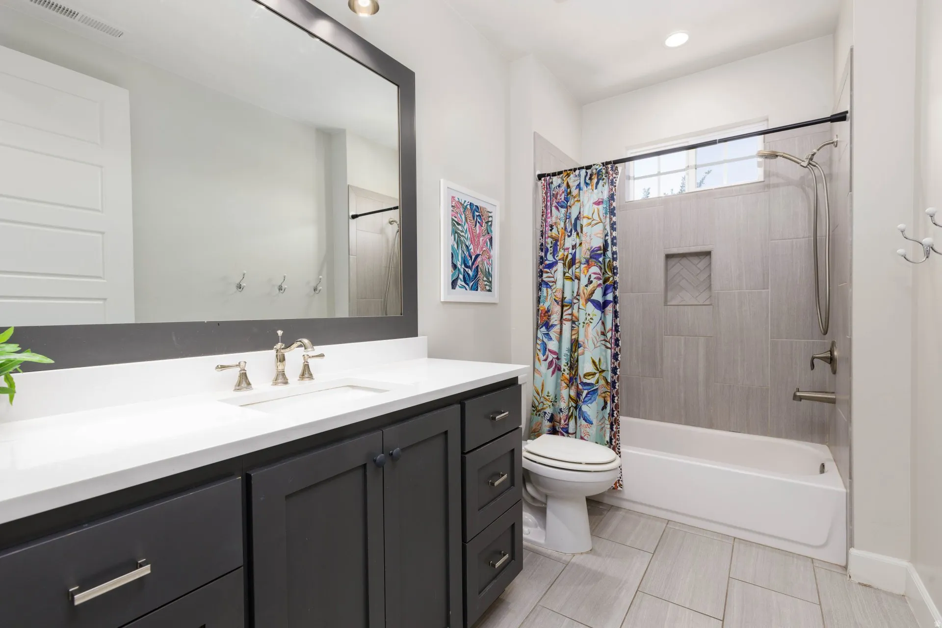 Bathroom featuring a dark gray vanity with white countertop, undermount sink, and brushed nickel fixtures