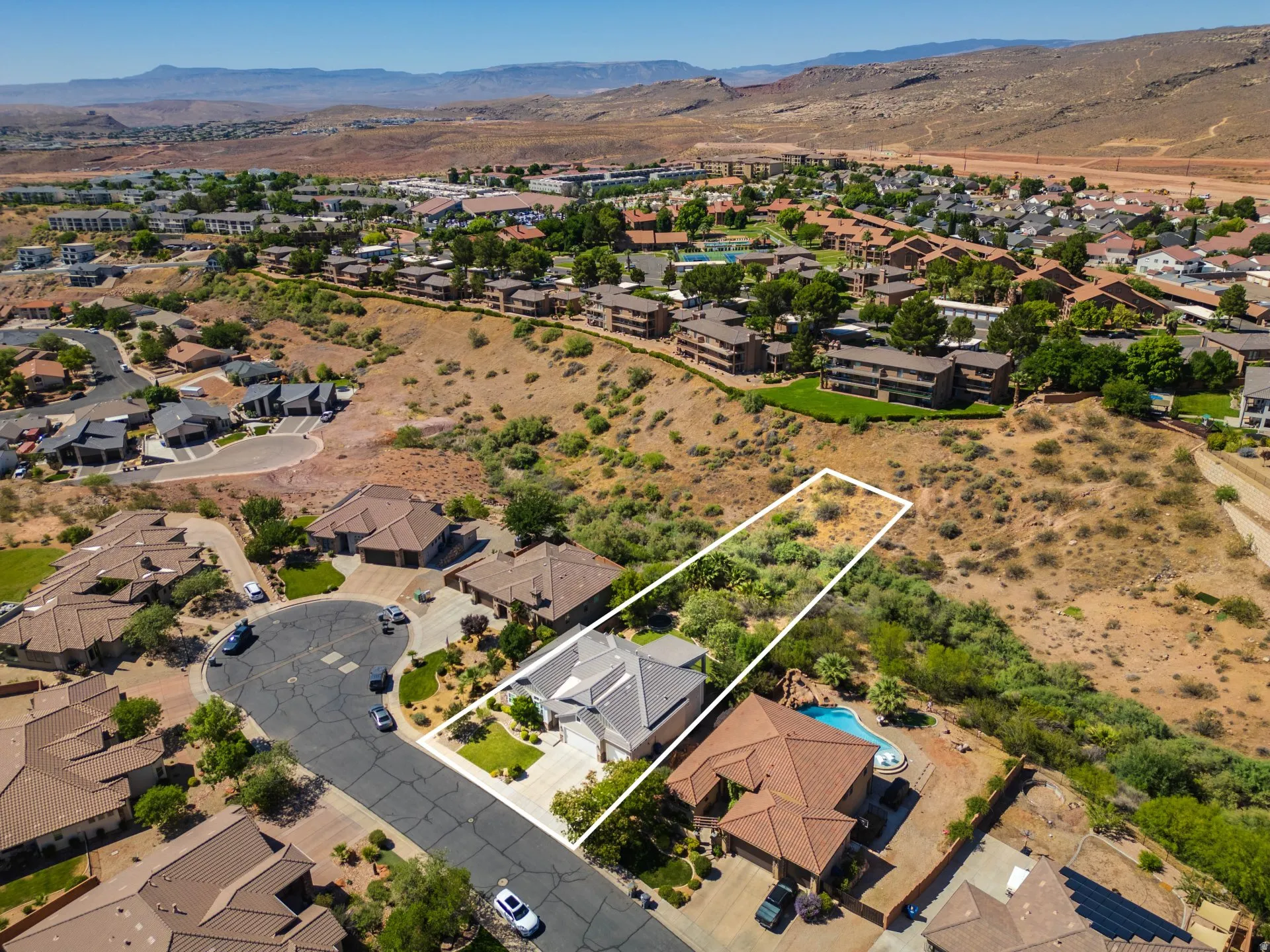 Aerial perspective showcasing a residential property with a light gray exterior and a dark gray roof