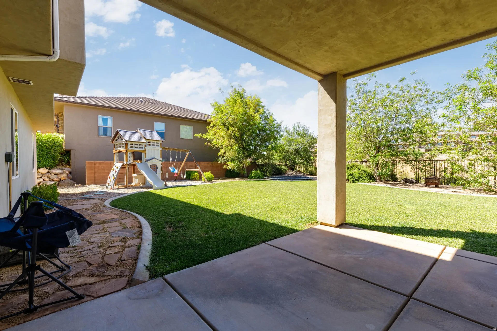 Covered patio with concrete slab flooring opening to a spacious lawn