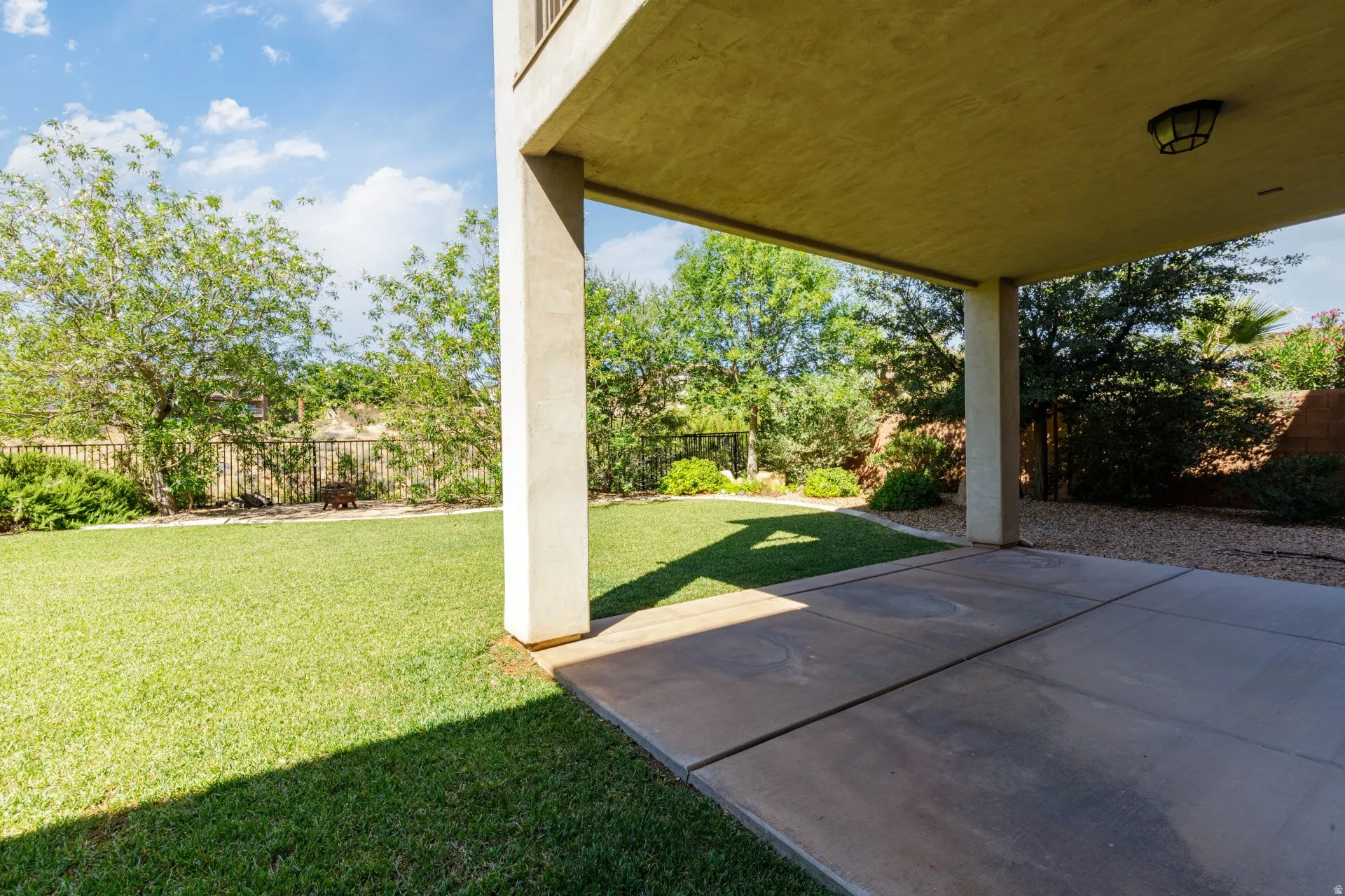Expansive covered patio featuring a concrete slab, recessed lighting fixture, and structural columns