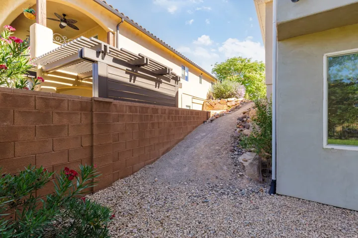 Terraced landscaping featuring a gravel pathway, a block retaining wall, and verdant plant beds