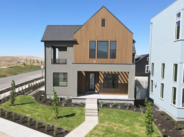 Contemporary exterior featuring a gabled roofline, wood-finish siding, and a covered entry porch