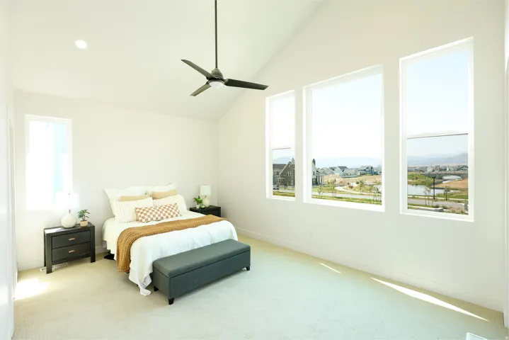 Vaulted ceiling, recessed lighting, ceiling fan, three large windows, and an additional single window