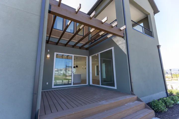 Expansive side deck with multi-level wood-finish decking and exterior wall sconces