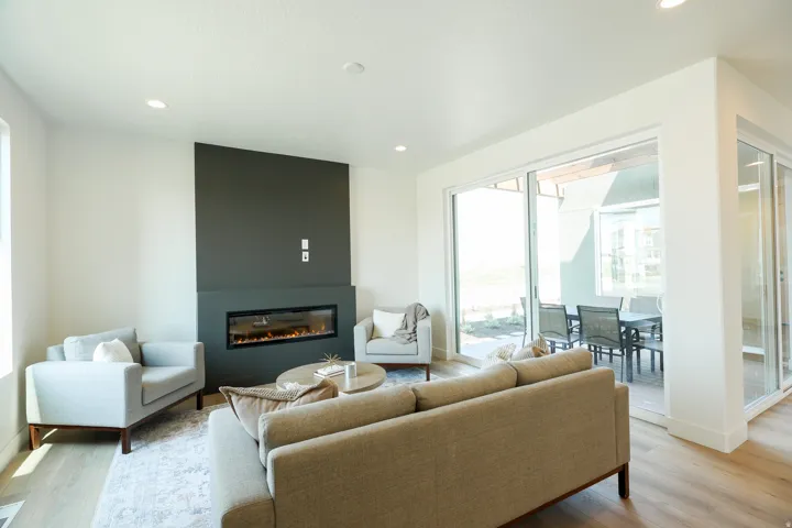 Built-in linear fireplace with a dark accent wall, recessed lighting, wood-finish flooring, and expansive sliding glass doors
