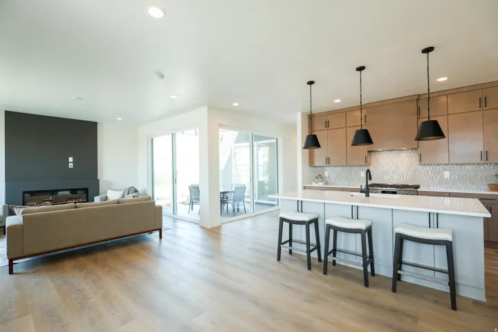 Wood-finish flooring, recessed lighting, and a linear fireplace with a dark accent wall