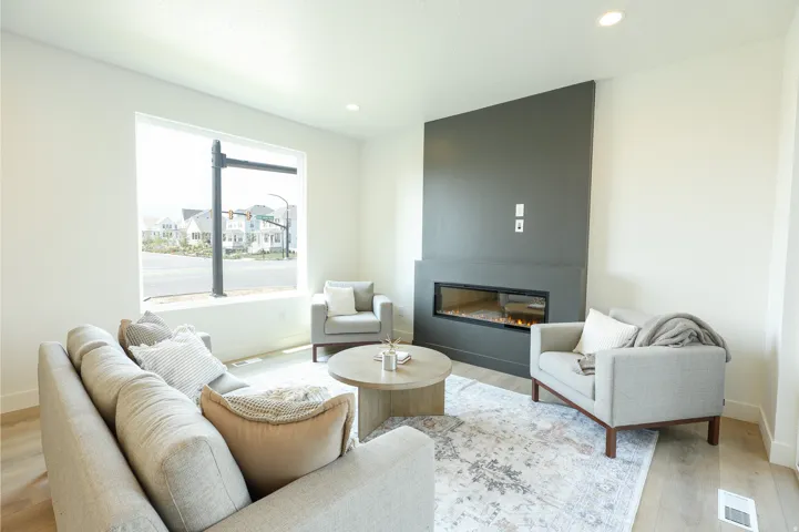 Recessed lighting, wood-finish flooring, a linear fireplace, and a large window
