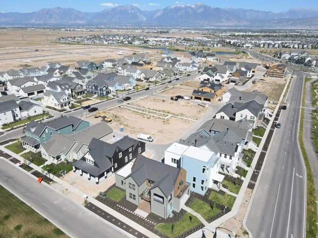 Developing residential community featuring a variety of architectural styles, paved roadways, and mountain backdrop