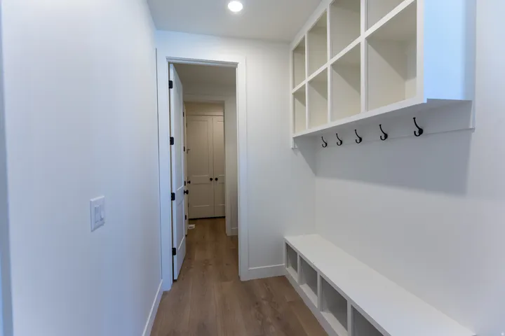 Built-in hall tree featuring upper cubbies, lower storage compartments, and black metal hooks