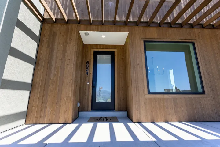 Modern exterior featuring wood-finish siding and a black-framed entry door