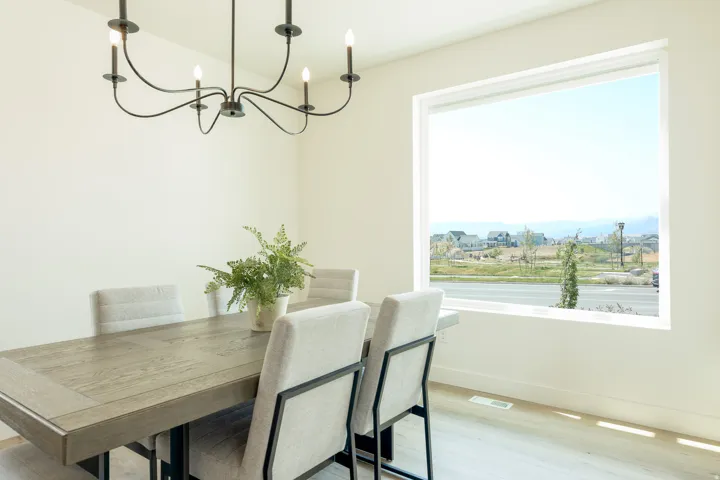 Large picture window, wood-finish flooring, and a modern chandelier