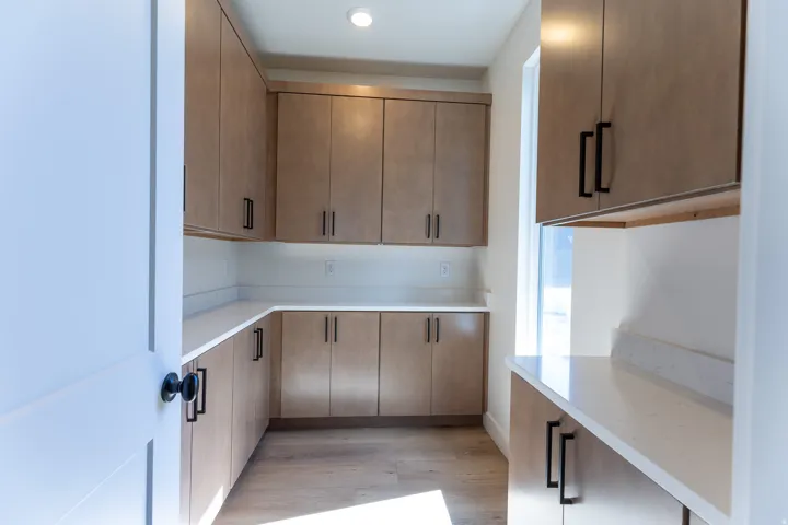 Pantry with cabinets and quartz countertops