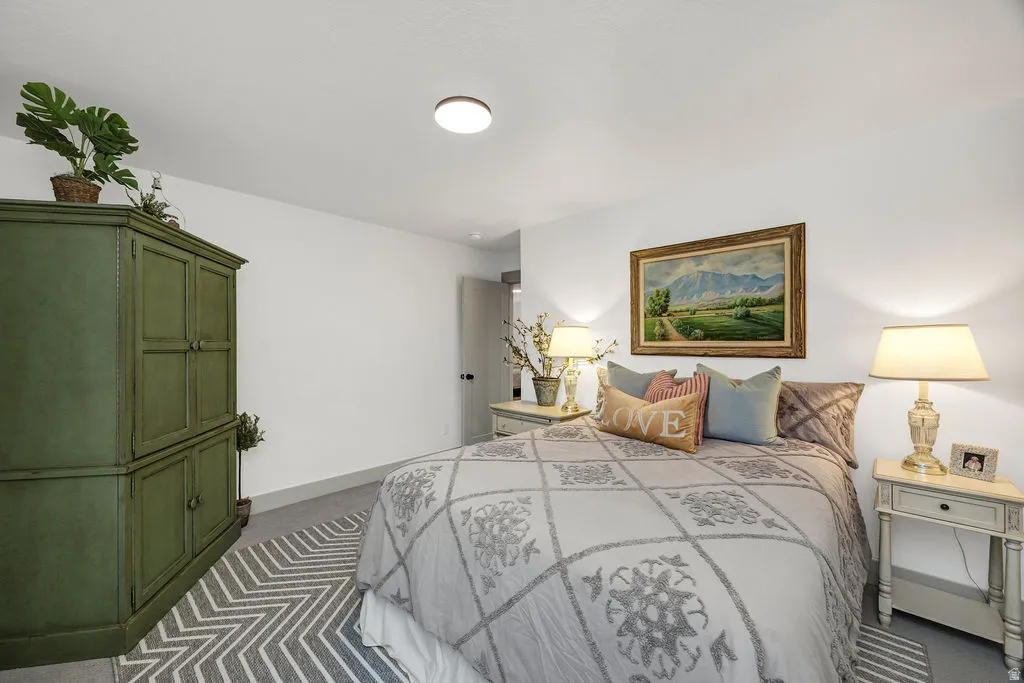 Carpeted bedroom featuring white walls and a ceiling light fixture
