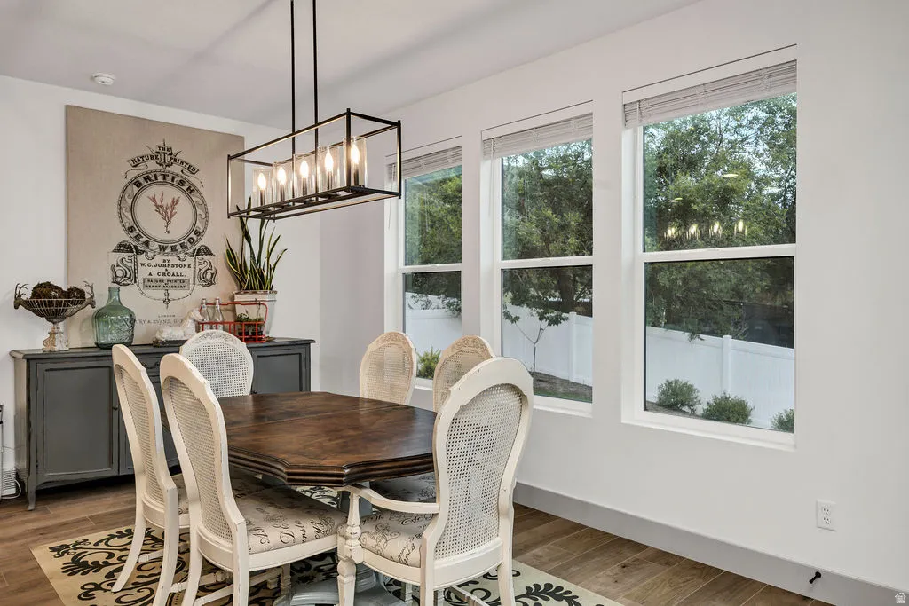 Dining area featuring wood-finish flooring, a linear chandelier, and a built-in sideboard