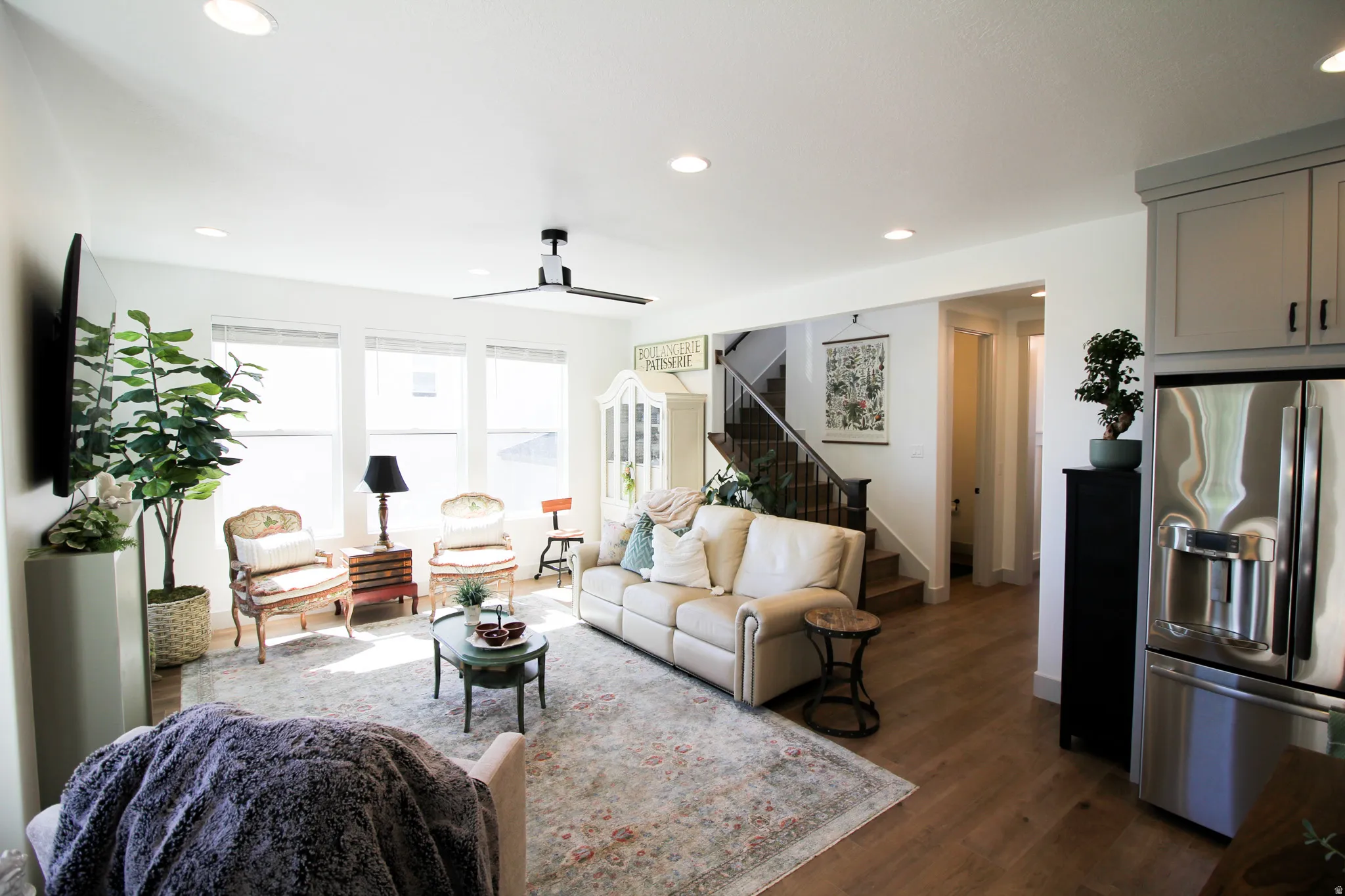 Open-concept living space with wood-finish flooring, recessed lighting, and a modern ceiling fan