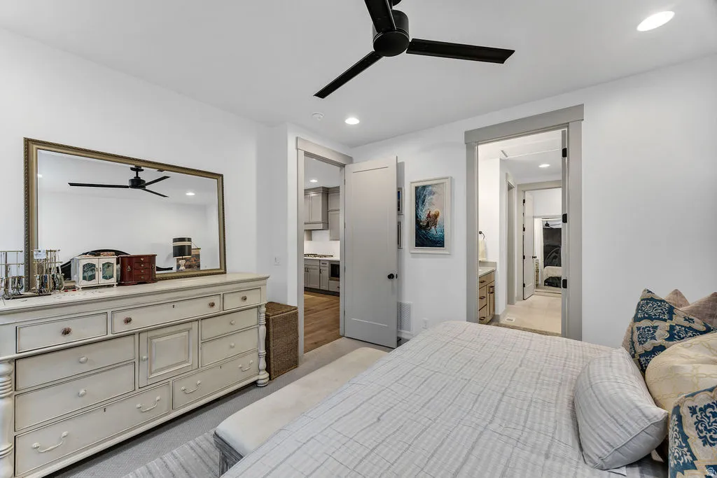 Recessed lighting and a matte black ceiling fan illuminate this interior space