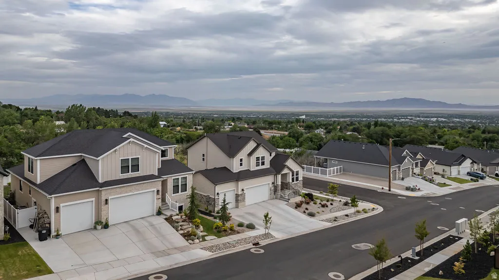 Newly constructed residence featuring a two-story design with a double garage, stone accents, and manicured landscaping