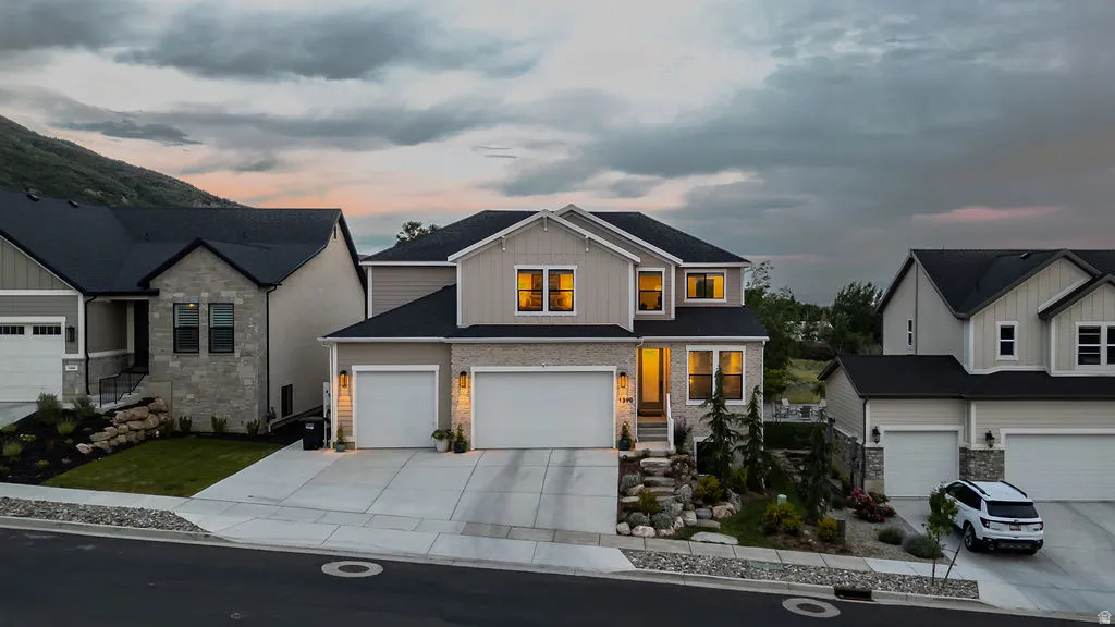Contemporary two-story residence featuring light siding and stone veneer accents
