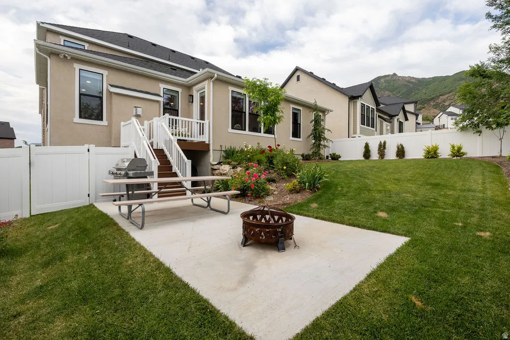 Rear exterior featuring a two-story design with a stucco finish and dark trim windows