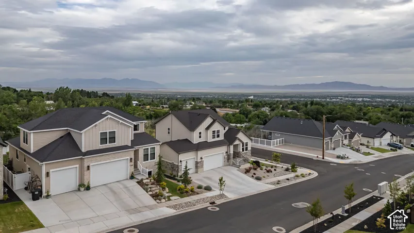 Newly constructed residence featuring a two-story design with a double garage, stone accents, and manicured landscaping