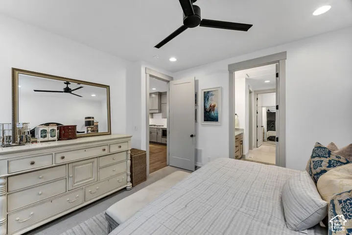 Recessed lighting and a matte black ceiling fan illuminate this interior space