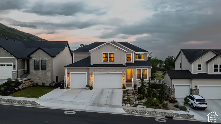 Contemporary two-story residence featuring light siding and stone veneer accents