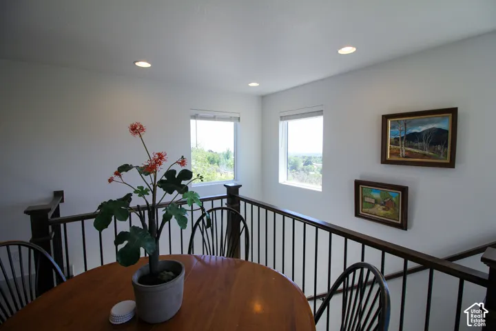 Upper-level landing featuring a dark wood railing with black metal spindles