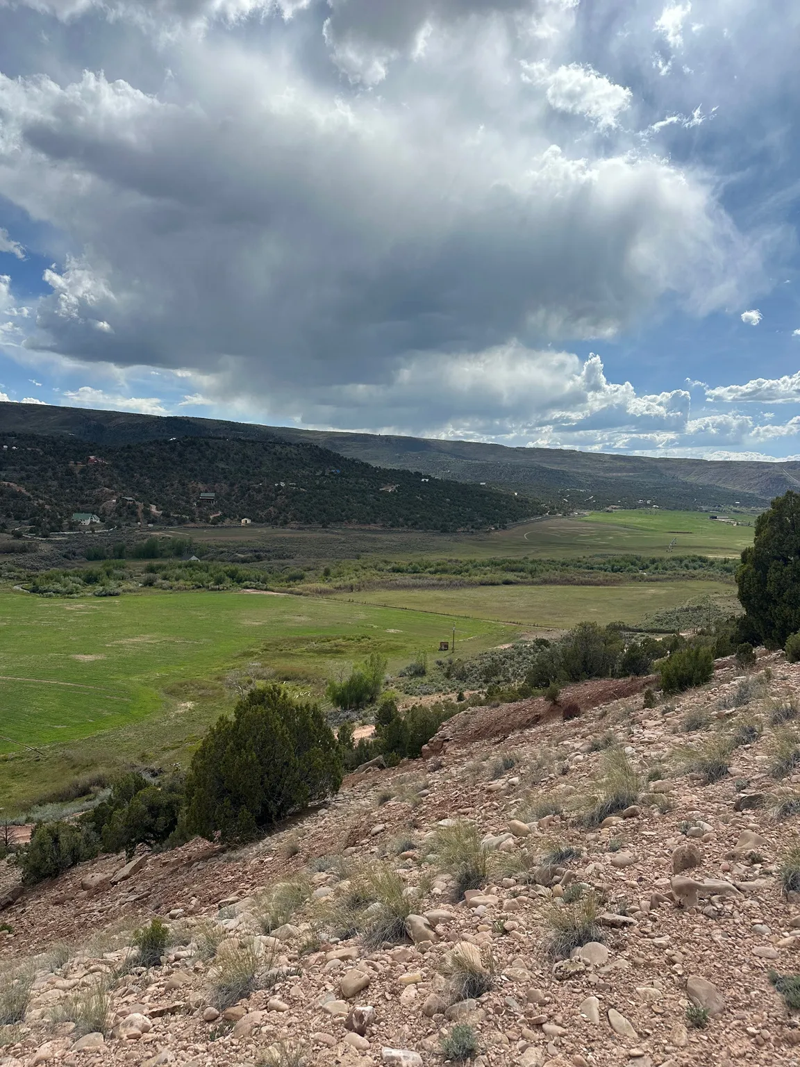 Expansive undeveloped land featuring a rocky, sloped terrain with scattered low-lying vegetation