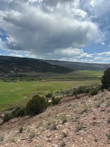 Expansive undeveloped land featuring a rocky, sloped terrain with scattered low-lying vegetation