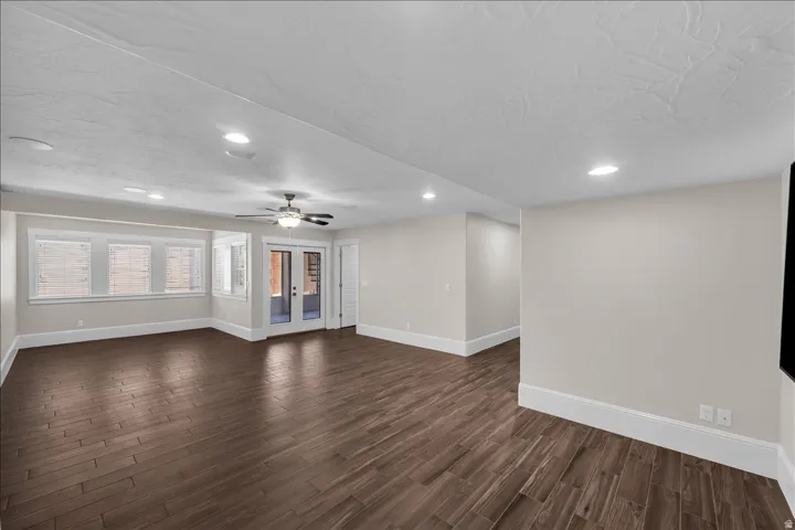 Spacious room featuring wood-finish flooring, recessed lighting, and a ceiling fan