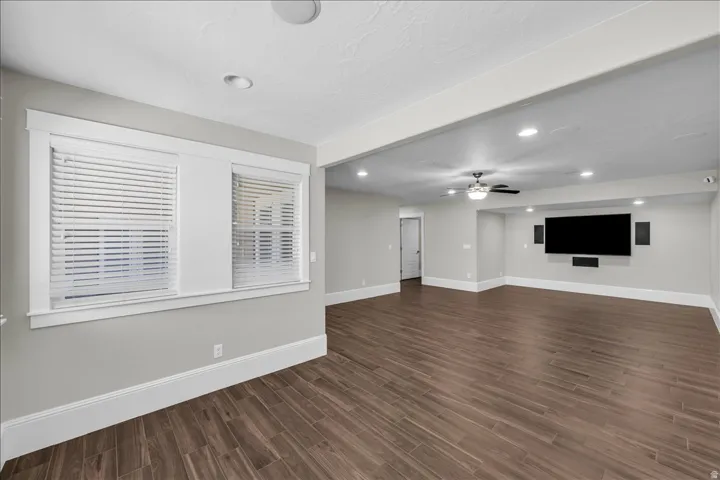 Spacious living area featuring wood-finish flooring, recessed lighting, and a ceiling fan