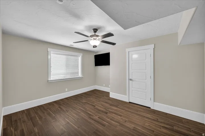 Spacious room featuring wood-finish flooring, neutral-toned walls, and white trim