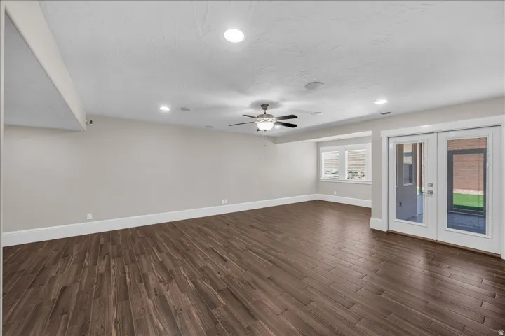 Spacious room featuring wood-finish flooring, recessed lighting, and a ceiling fan