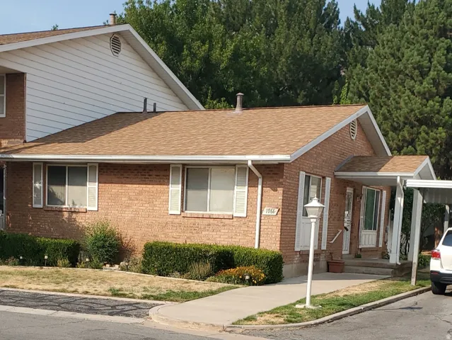 Brick exterior with white shutters and a tan shingle roof