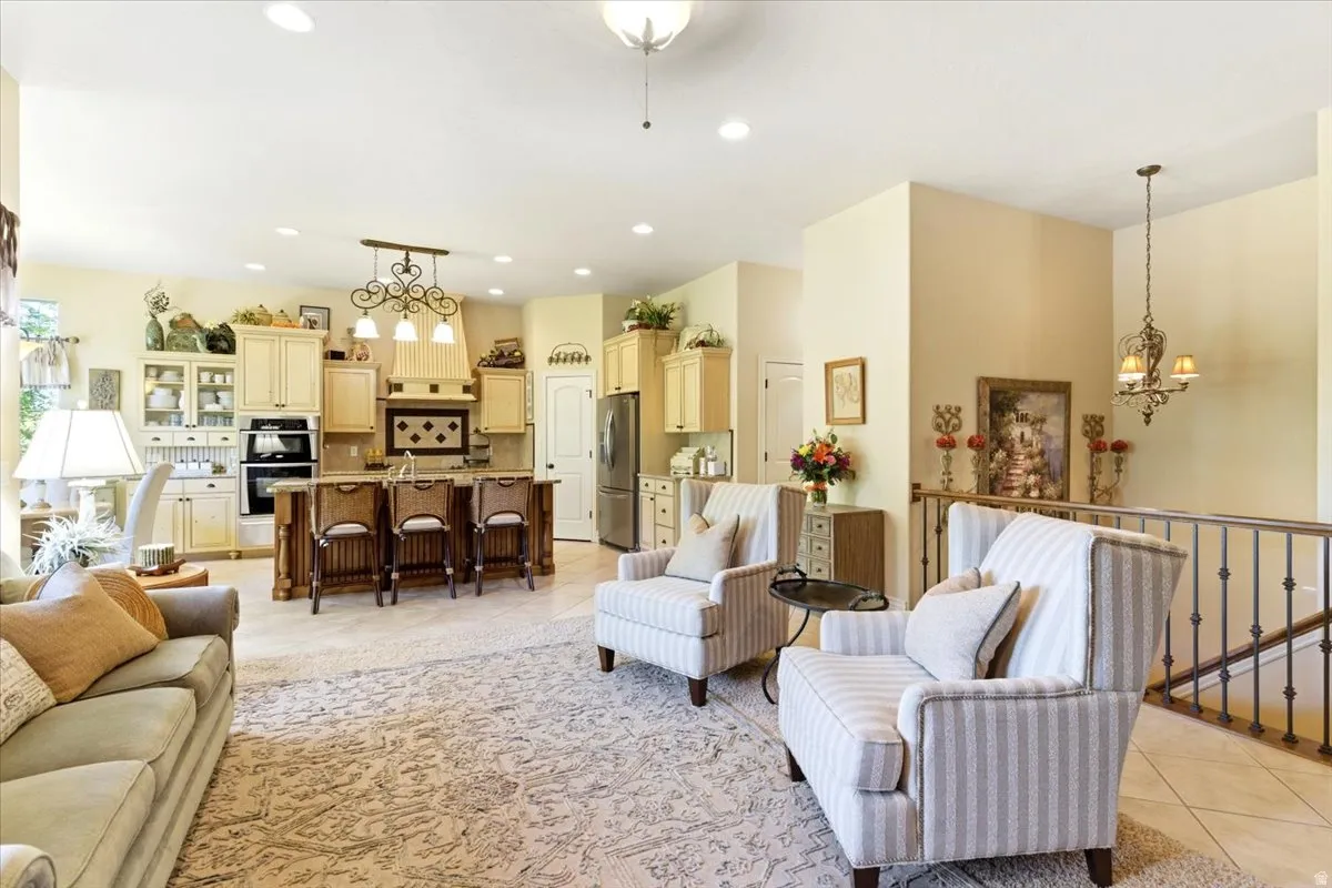 Spacious living area featuring high ceilings, light-toned walls, and a wrought iron staircase railing
